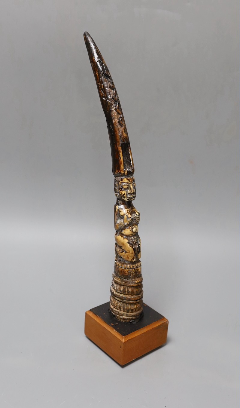 An African carved ivory divination tapper, probably Yoruba tribe on stand, 35 cms high.